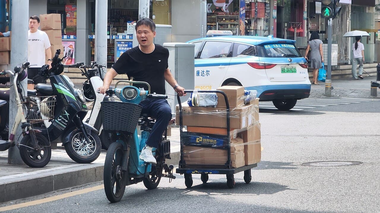A courier hauling parcels through Huaqiangbei