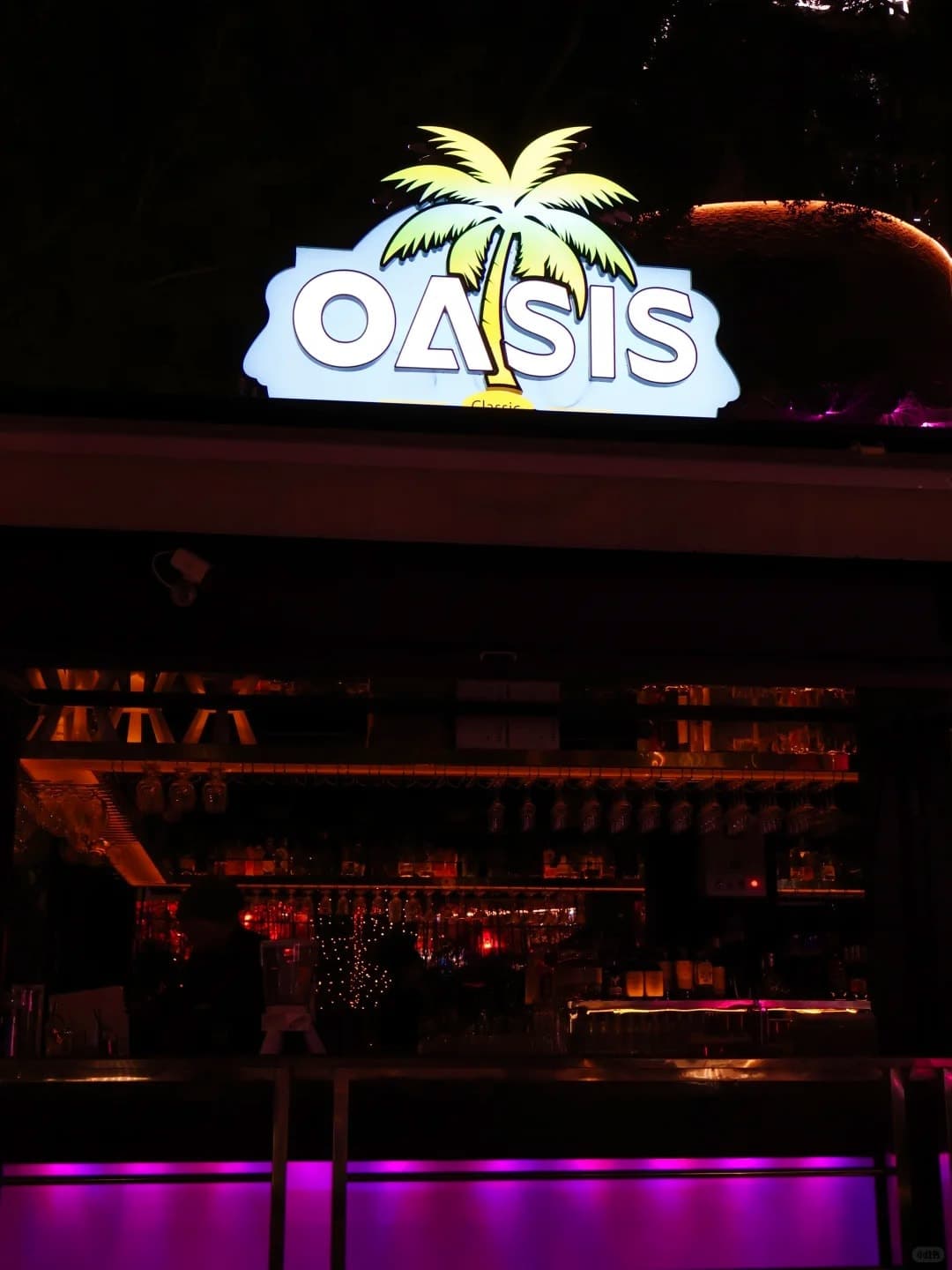 The OASIS palm-tree sign over the bar